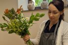 Eine Frau hat enen bunten Blumenstrauß in der Hand.